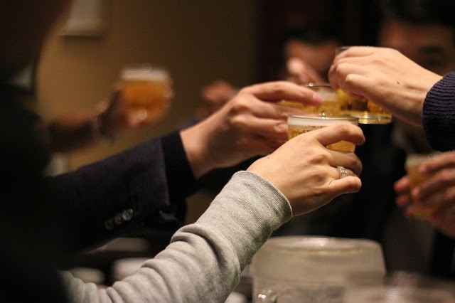 Japanese work colleagues saying kanpai at a nomikai event.